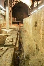 Canal de agua entre muros de piedra en el interior del complejo histórico