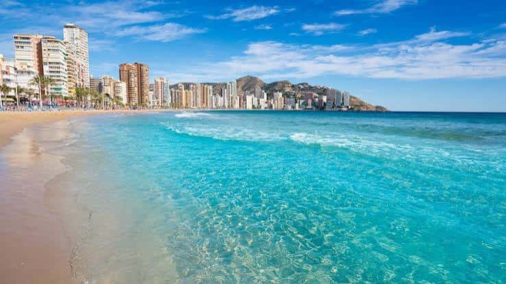 Playa de Levante con aguas turquesas y el skyline de Benidorm al fondo