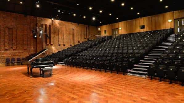 Interior del auditorio Turner Sims con piano en el escenario y butacas vacías