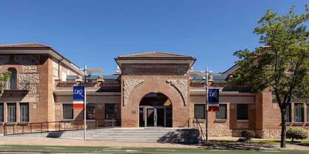 Fachada principal del DA2 Domus Artium 2002 con arcos de ladrillo y banderas institucionales