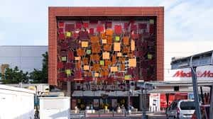 Fachada exterior del Centro Comercial Área Sur con panel decorativo de colores y entrada principal