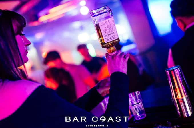 Bartender sirviendo bebida en el bar Bar Coast