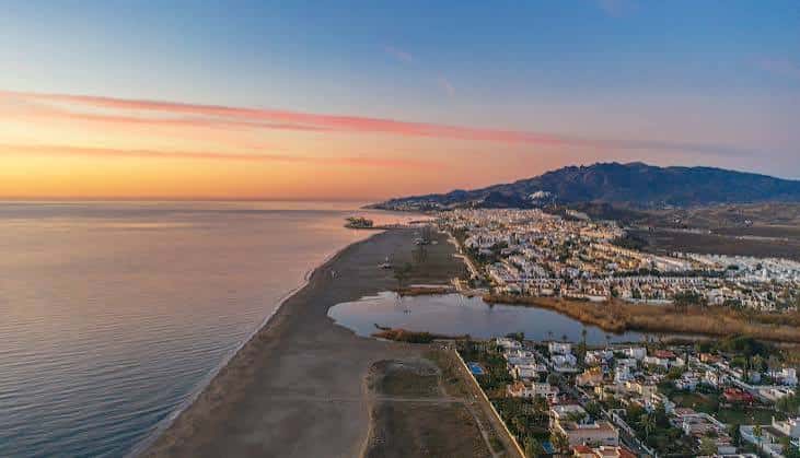 Vista aérea de la costa de Vera al atardecer con el mar y la ciudad