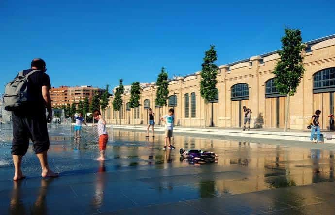 Plaza con fuente de agua y personas disfrutando del espacio público en el Parque Central de Valencia