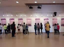 Exposición en sala interior con visitantes observando paneles