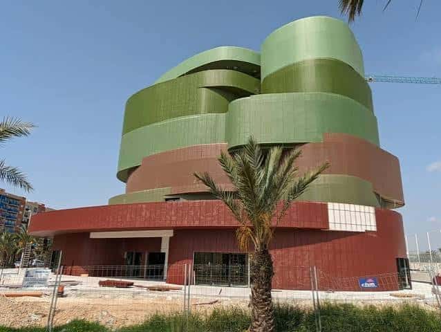 Vista exterior del Edificio Valona con su distintiva fachada curva en tonos verdes y rojos