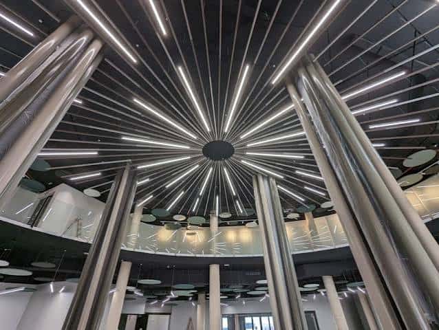 Interior del edificio mostrando el techo con diseño de rayos y columnas metálicas