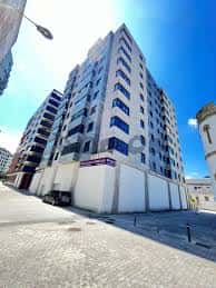 Vista exterior del edificio moderno en Rúa Soto Freire con fachada blanca y ventanas azules