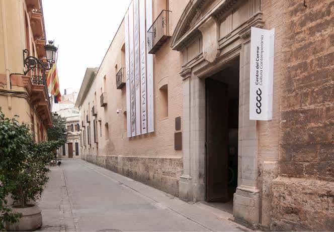Fachada exterior del edificio con la entrada principal y banderas