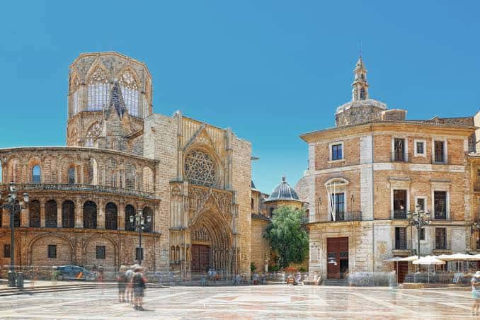 Fachada gótica de la Catedral de Valencia y edificio adyacente en la plaza
