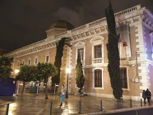 Vista nocturna de la fachada de la Plaza del Patriarca con iluminación cálida y árboles altos