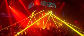 Interior del Circuit Club con luces láser rojas y amarillas sobre la pista de baile