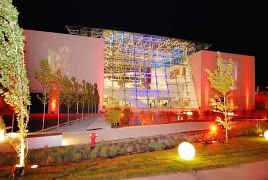 Vista nocturna del museo con iluminación arquitectónica y fachada de cristal iluminada