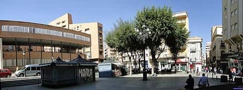 Vista panorámica de la Plaza Mayor en Albacete con edificios modernos y árboles en un día soleado