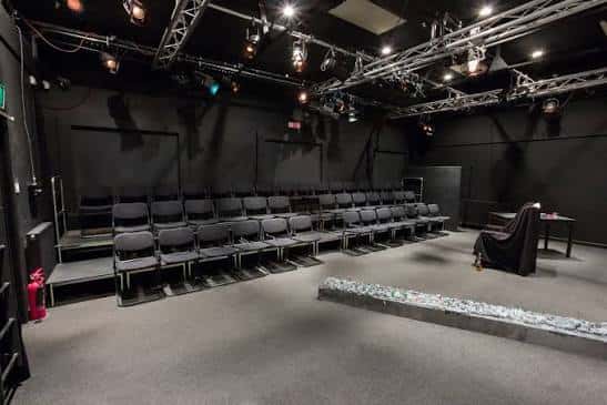 Interior del auditorio con butacas grises y sistema de iluminación profesional