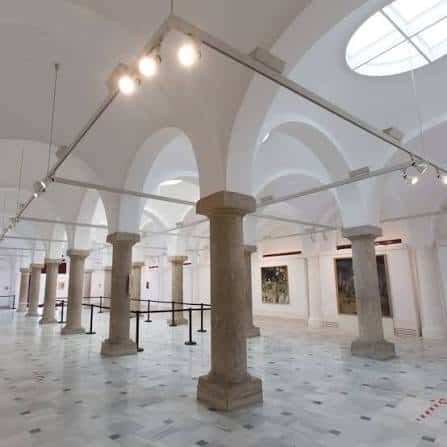 Interior de la Sala Pescadería Vieja con columnas de piedra y bóvedas blancas