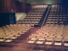 Interior del auditorio con butacas dispuestas para eventos culturales