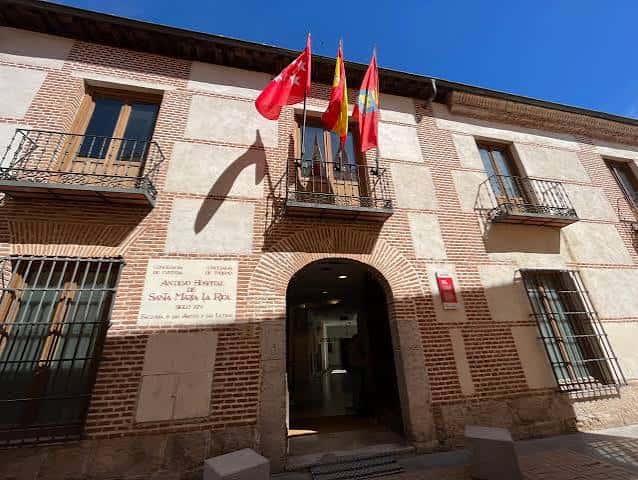 Fachada principal del Antiguo Hospital de Santa María la Rica con banderas ondeando