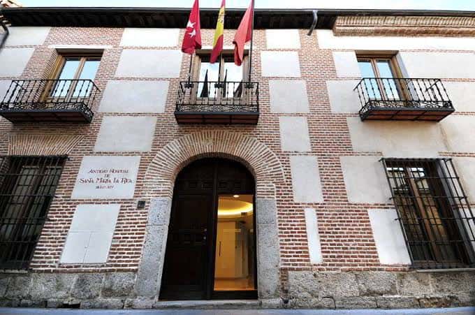 Entrada monumental del edificio con arco de ladrillo y balcones históricos