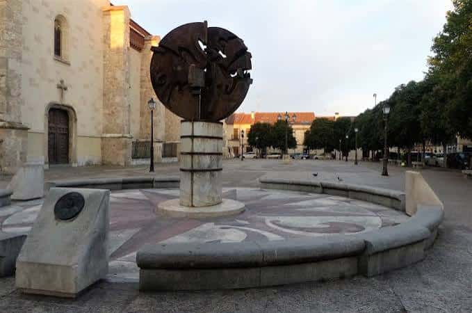 Detalle de la escultura metálica y el reloj de sol en la plaza