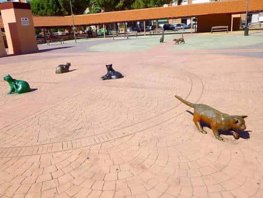 Vista general de la Plaza de los Gatos con esculturas de gatos de colores sobre el pavimento de ladrillo