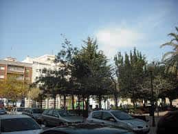 Vista de la Plaza Mayor de Pinedo con árboles y edificios residenciales al fondo