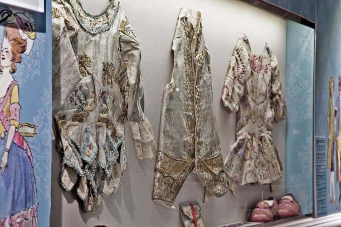 Trajes de época bordados expuestos en vitrina del museo