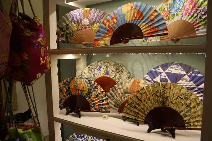 Colección de abanicos decorativos y bolsos de seda en exhibición