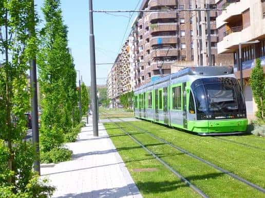 Tranvía verde circulando por la Avenida de Gasteiz con vías en césped