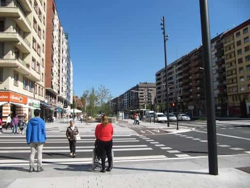 Cruce peatonal en la Avenida de Gasteiz con personas caminando y edificios a ambos lados