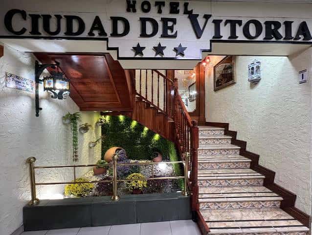 Entrada principal del hotel con escalera de madera y letrero de tres estrellas