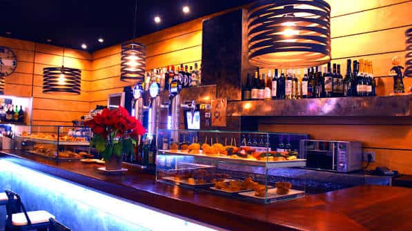 Interior del Bar Txalaparta con barra de madera, botellas y decoración cálida