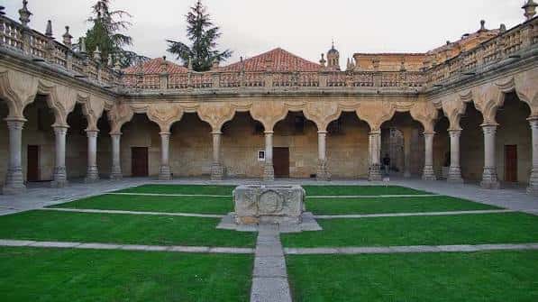 Vista panorámica del Patio de las Escuelas Menores con su césped central y arcos de piedra
