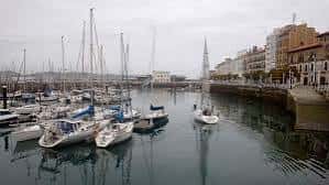 Puerto deportivo de la Dársena de Fomentín con veleros amarrados y arquitectura urbana al fondo