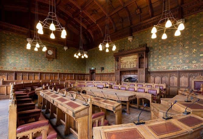 Sala de reuniones histórica con mobiliario de madera y paredes decoradas