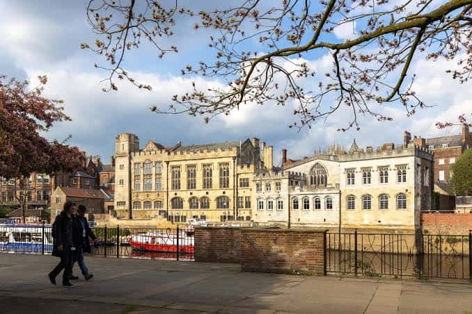 Fachada del Guildhall con árboles en primer plano y peatones