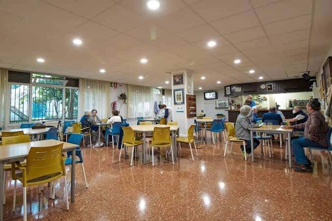 Sala de comedor interior con mesas y sillas de colores