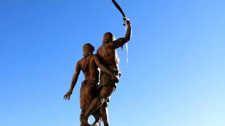 Estatua de Indíbil y Mandonio contra el cielo azul, vista desde abajo con espada levantada