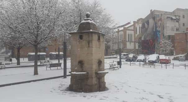 Vista general de la Plaza del Depósito en invierno con el monumento central cubierto de nieve
