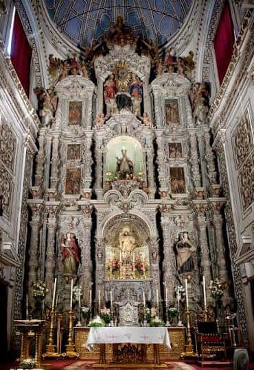 Altar principal del Convento de San Leandro con retablo barroco y decoración ornamental