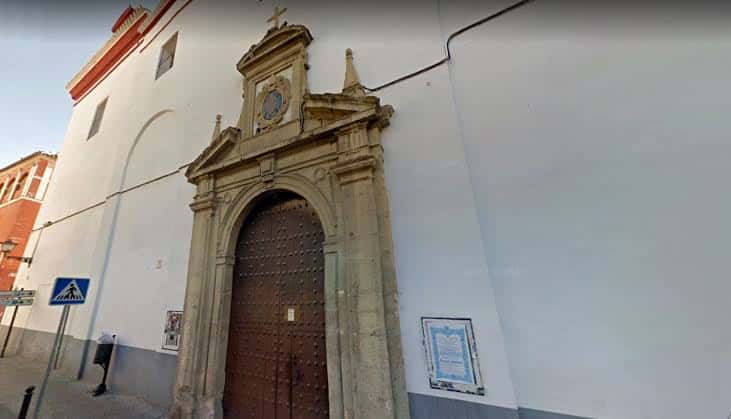 Fachada exterior del Convento de San Leandro con puerta de madera y detalles arquitectónicos