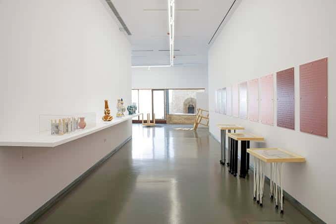 Interior de la Galería Alarcón Criado con obras de arte expuestas en paredes blancas y vitrinas