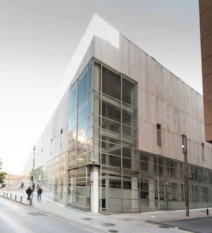 Ángulo exterior de la biblioteca mostrando su diseño arquitectónico con cristal y hormigón