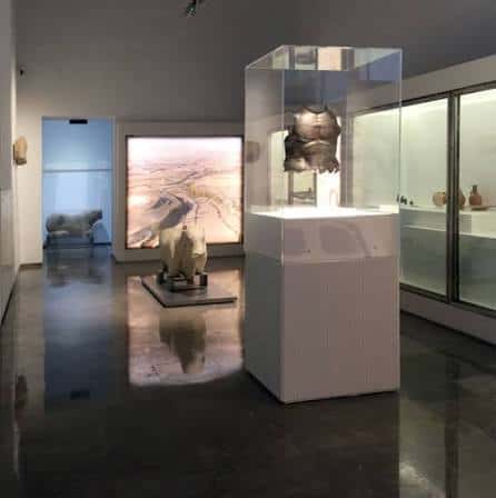 Exposición interior del museo con vitrinas y piezas arqueológicas