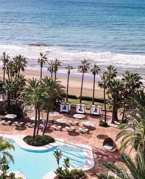Vista aérea de la piscina, playa y palmeras del Don Carlos Resort