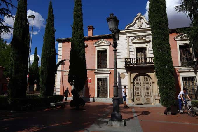 Edificio de la Plaza de Palacio con cipreses y farola clásica
