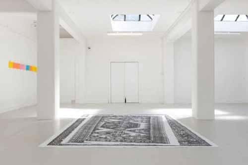 Interior blanco minimalista de KARST con instalación artística en el suelo
