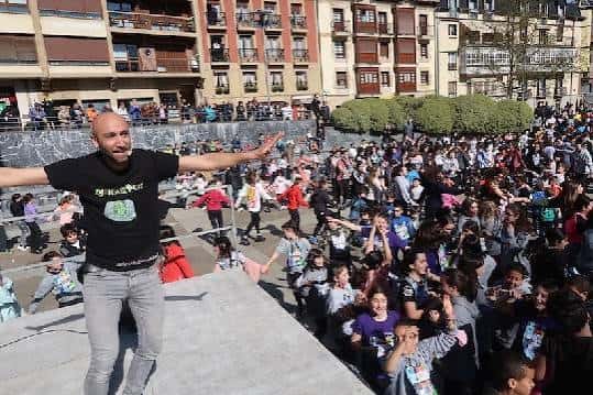 Presentador en escenario frente a multitud de niños en plaza del parque