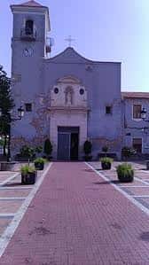 Fachada principal de la Iglesia de Nuestra Señora de Cortes en Nonduermas, con plaza adoquinada y maceteros