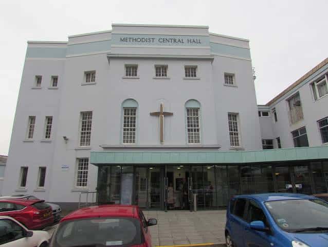 Fachada exterior del Plymouth Methodist Central Hall con cruz y letrero visible